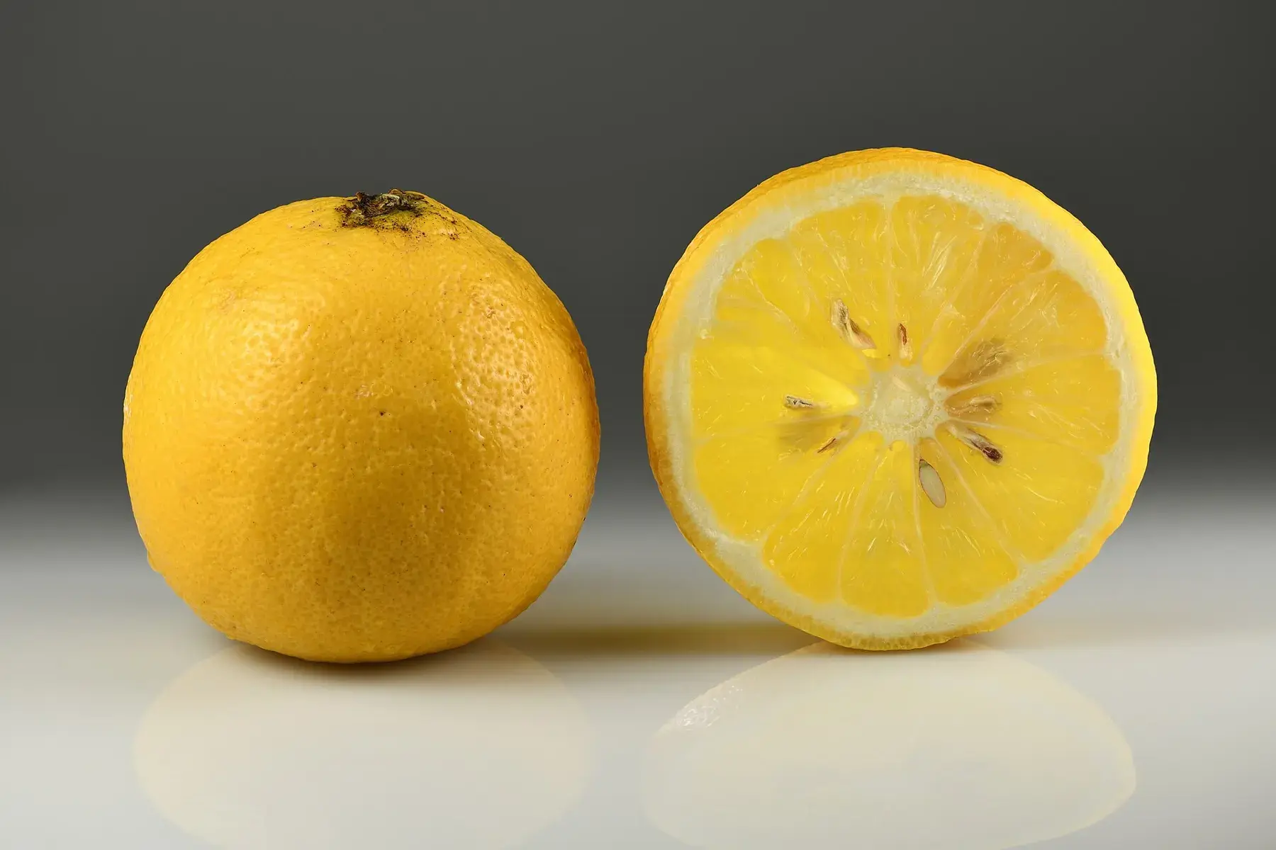 A whole bergamot orange next to a cut slice